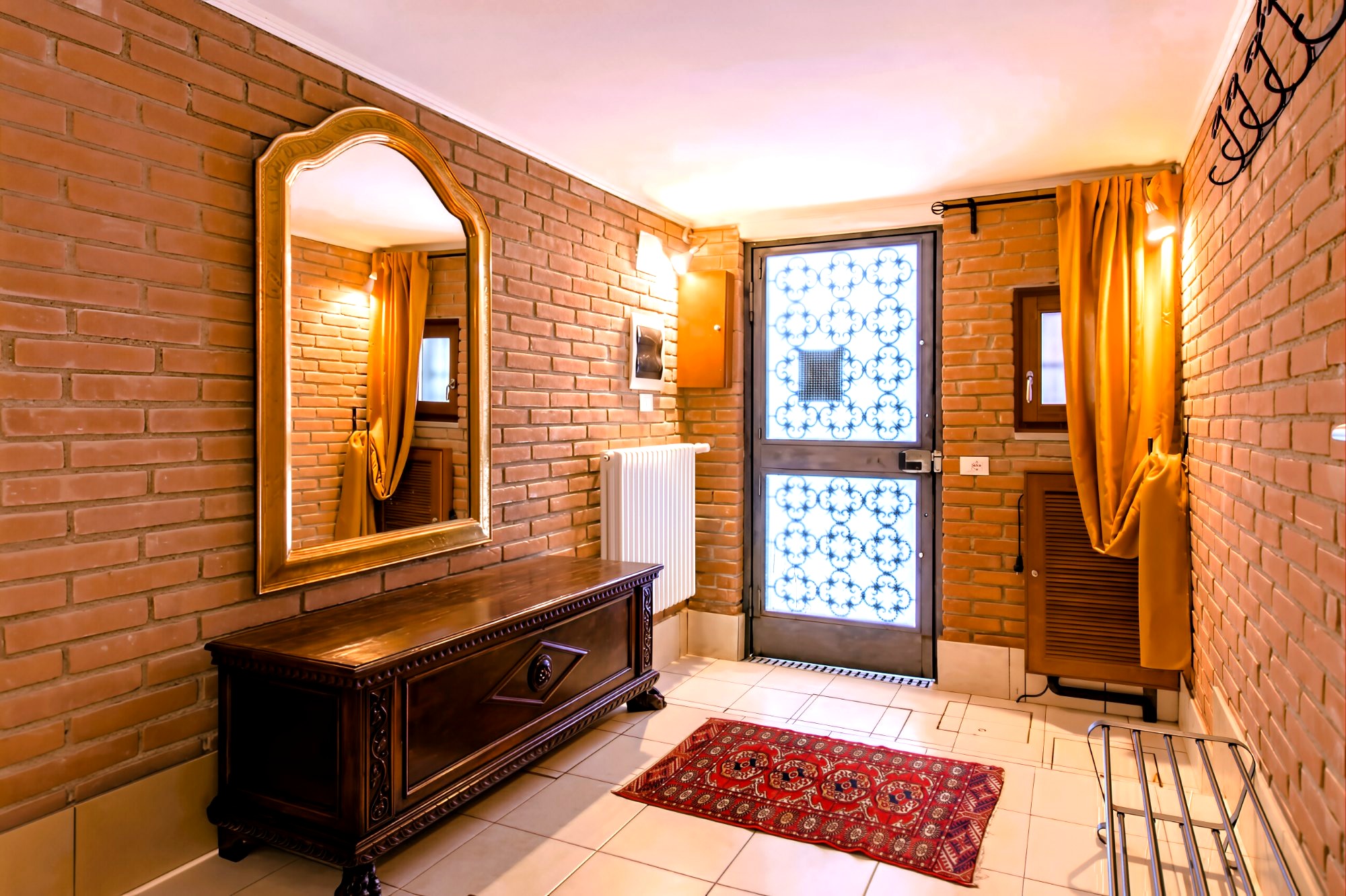 La Serenissima entrance hall — exposed brick and antique mirror